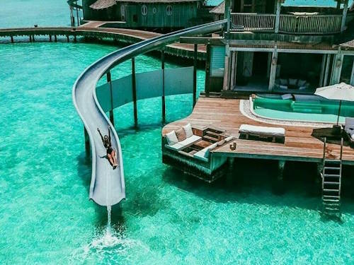 Luxury Maldives overwater villa with private waterslide into turquoise lagoon