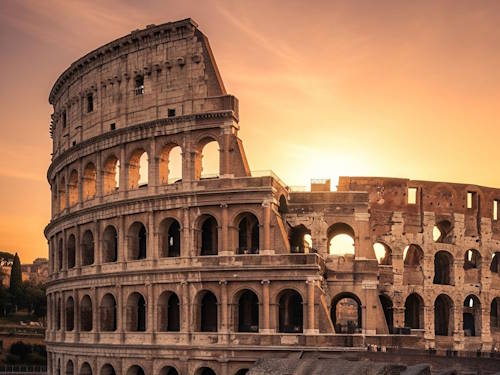 The Colosseum in Rome, Italy beautifully lit by a golden sunset sky
